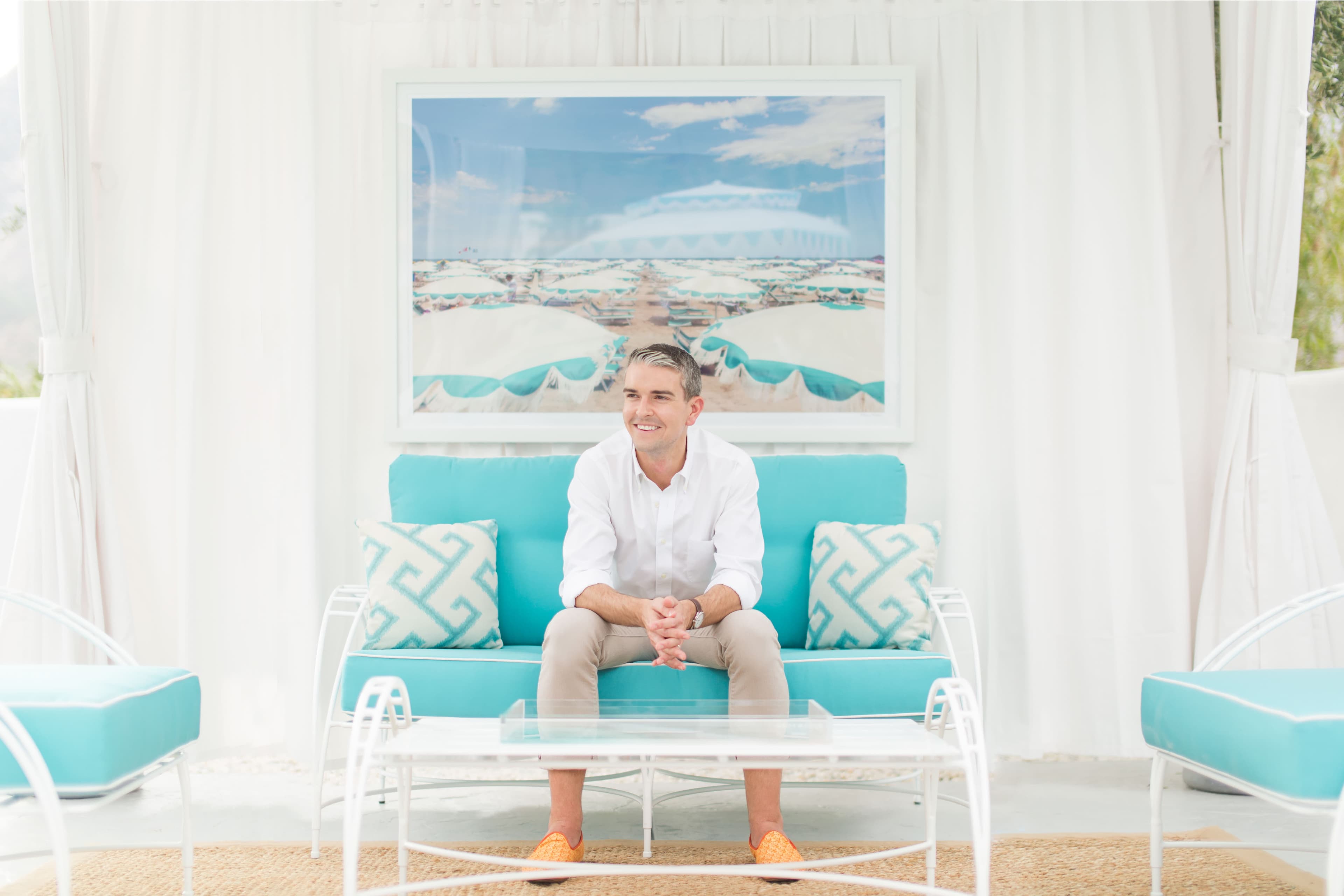 Gray sitting with one of his photographs behind him